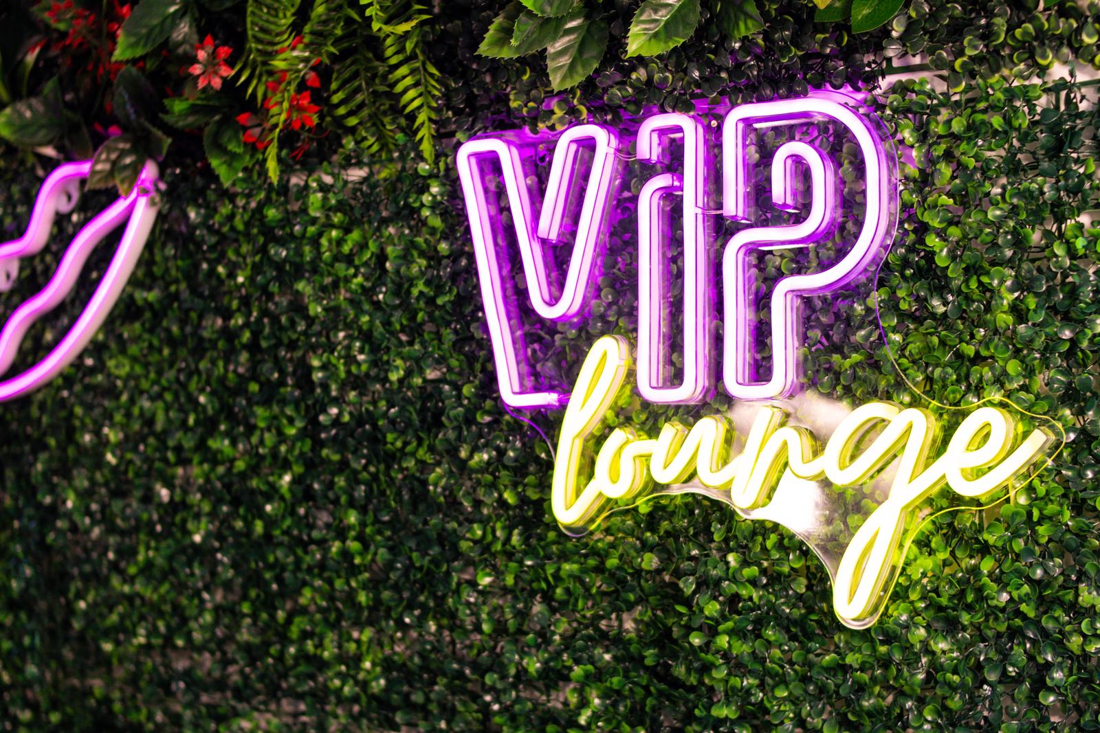 Insegna neon VIP lounge sulla parete verde